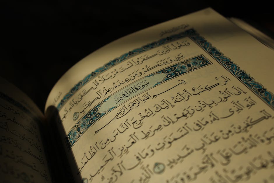 Foto sebuah naskah kitab kuning klasik yang terbuka di atas meja kayu dengan pencahayaan hangat, menunjukkan teks Arab yang ditulis dengan khat indah, melambangkan kedalaman tradisi keilmuan Islam.