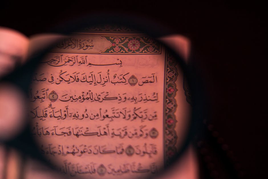 Foto sebuah mushaf Al-Quran kuno yang terbuka di atas meja kayu berukir di dalam perpustakaan klasik dengan cahaya matahari pagi yang masuk melalui jendela masjid, menciptakan suasana tenang dan penuh ilmu.