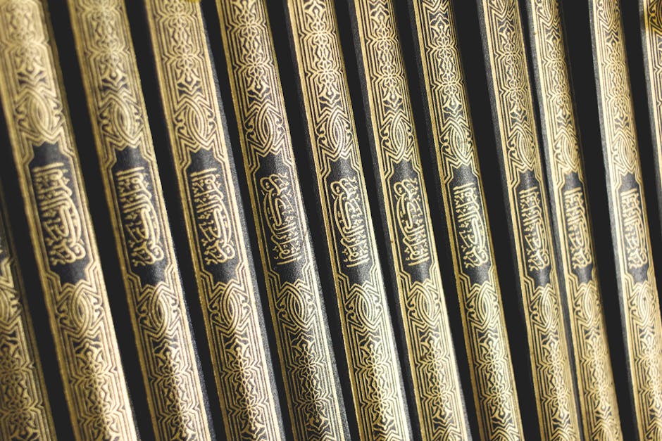 Foto sebuah mushaf Al-Quran kuno dengan tulisan kaligrafi yang indah terbuka di atas meja kayu di dalam perpustakaan klasik yang dipenuhi kitab-kitab kuning, menciptakan suasana keilmuan yang mendalam dan tenang.